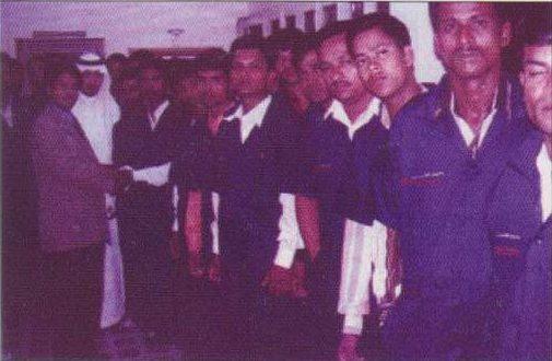 Selected workers lined up with officials before departure