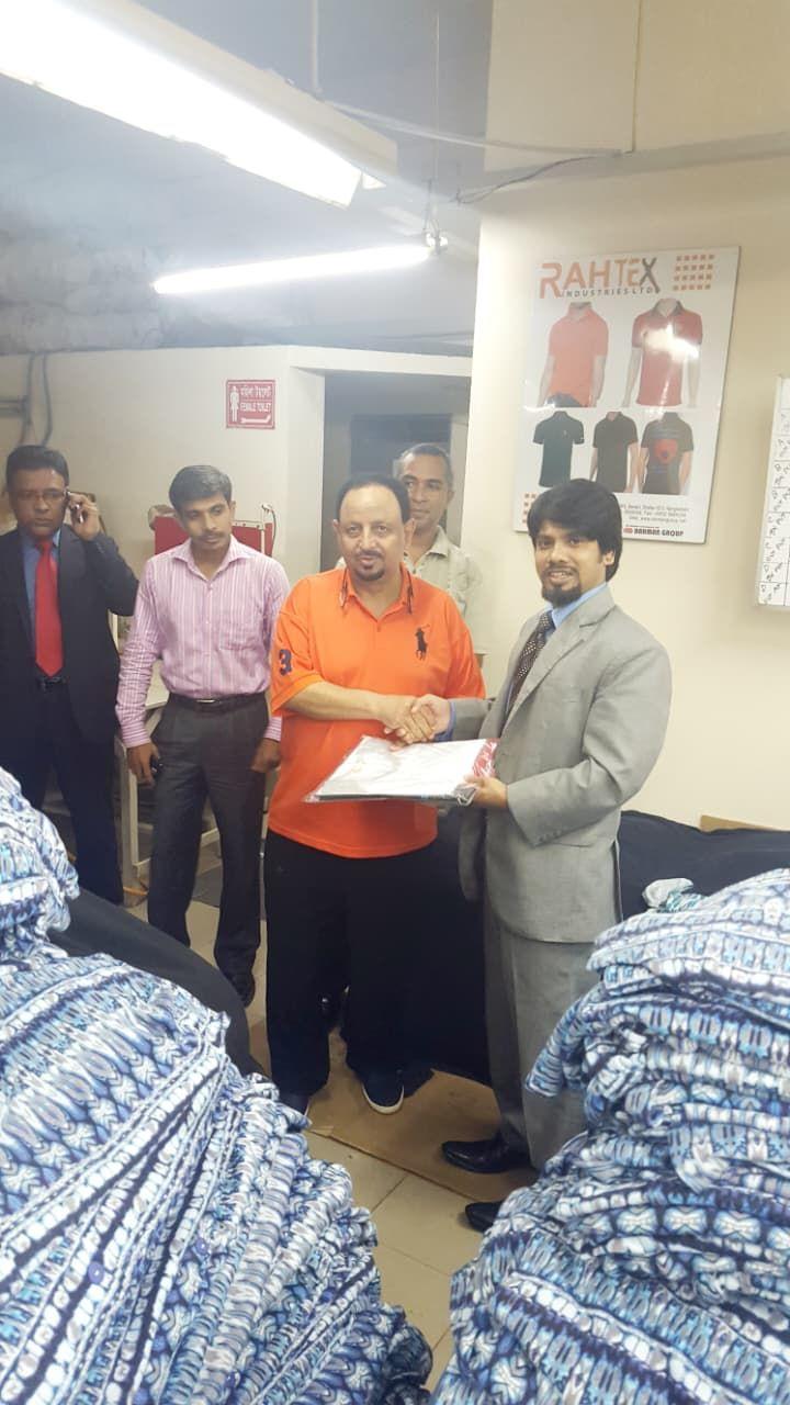 A buyer and a Rahtex manager exchanging documents on the factory floor