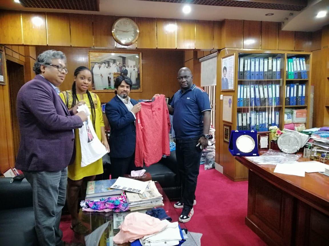 Visiting buyers holding up a shirt sample in the Chairman's office